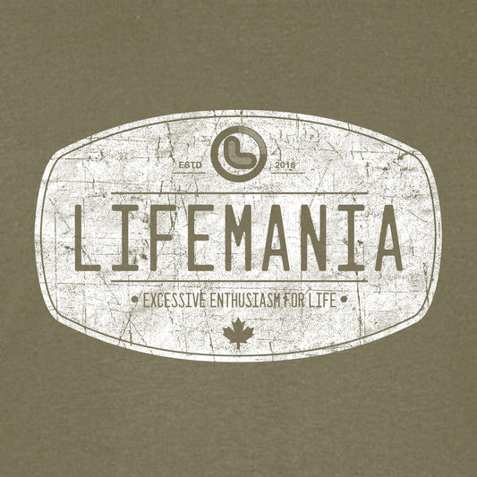 A white Lifemania vintage distressed oval design t-shirt on a green background.