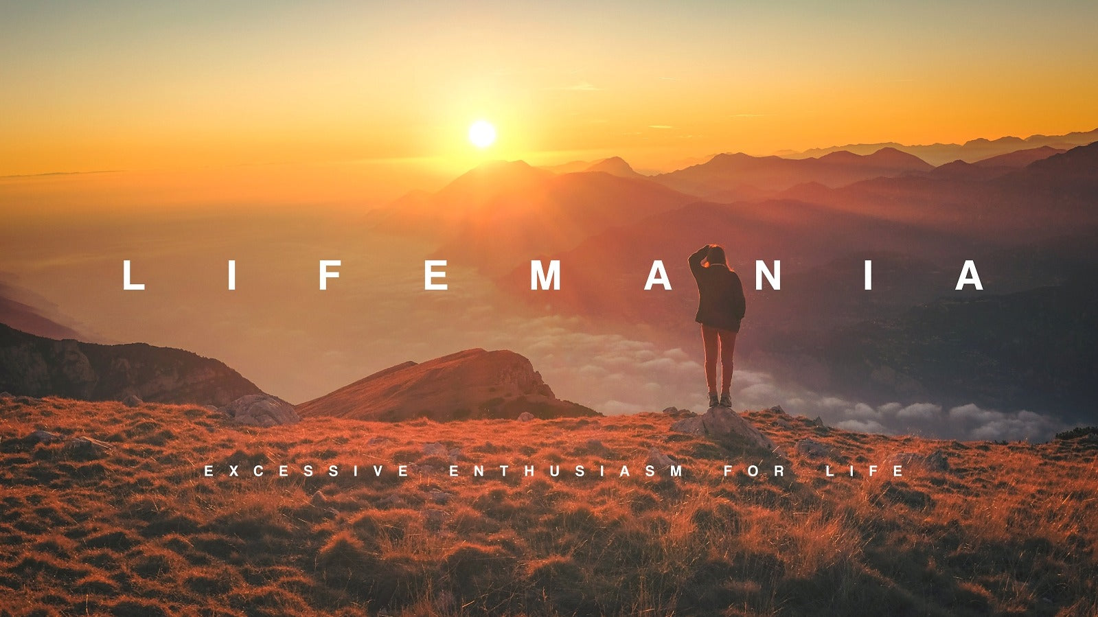 Person standing on a mountain with a sunset and 'LIFEMANIA' text overlay